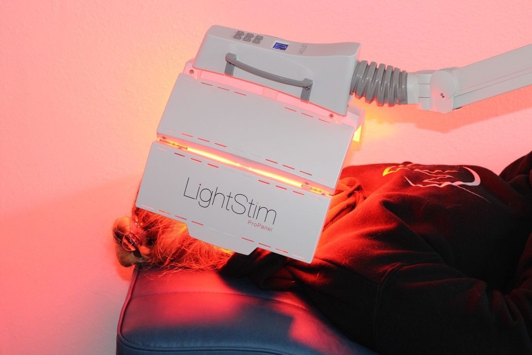 A skincare professional using LED LightStim therapy on a patient, showcasing its benefits for radiant and rejuvenated skin
