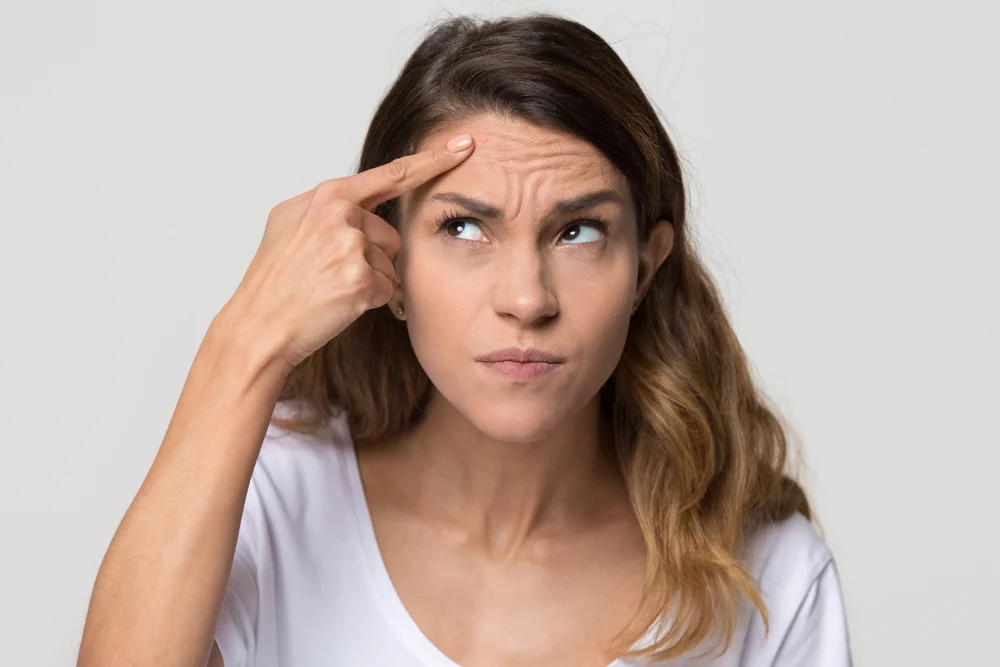 Concerned woman evaluating if she is a good candidate for VTone treatment, a non-surgical solution for pelvic floor strengthening and urinary incontinence.