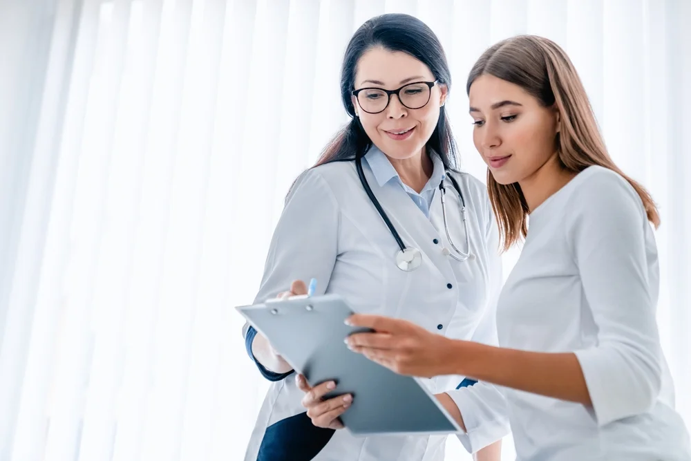 Doctor discussing potential side effects and risks of FormaV vaginal rejuvenation treatment with a patient, ensuring informed decision-making.