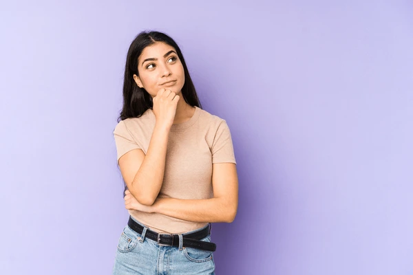 Woman thoughtfully considering if she is a good candidate for Evolve fat reduction treatment