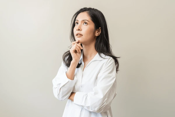 Woman thoughtfully considering if she is a good candidate for Xeomin treatment to reduce wrinkles and enhance her appearance