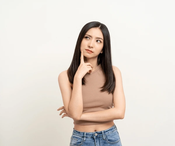 Young woman thoughtfully considering if she’s a suitable candidate for Juvederm Volbella XC lip enhancement treatment
