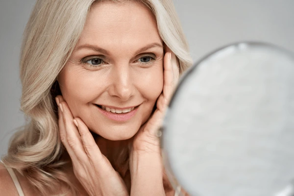 Middle-aged woman assessing skin for Morpheus8 treatment suitability for wrinkle reduction and skin tightening