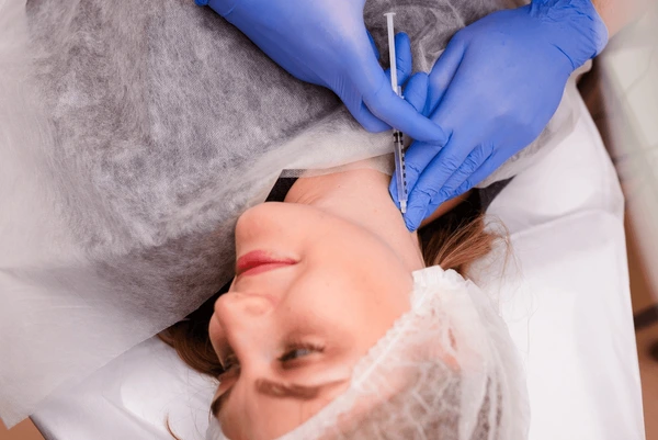 Woman receiving Dysport injection for platysma band relaxation to improve neck appearance and reduce visible neck lines