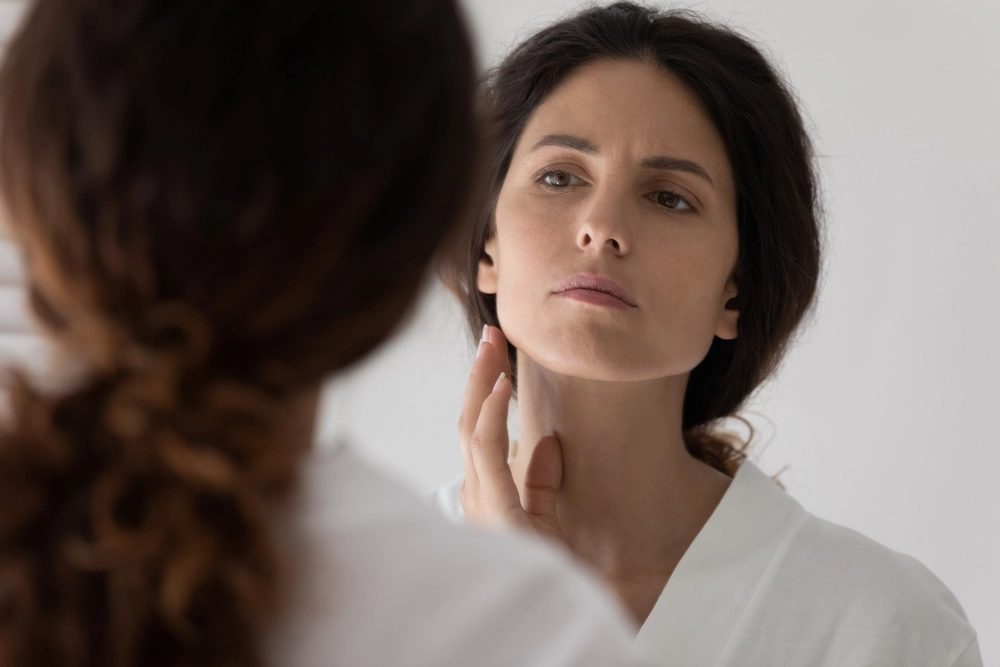 Woman examining skin for potential side effects of Soprano ICE Platinum laser treatment.