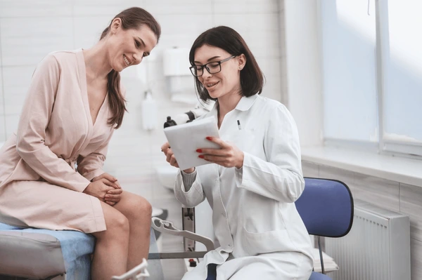 Doctor discussing TempSure Vitalia treatment preparation with a patient in a clinical setting for non-invasive vaginal rejuvenation.