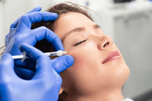 Woman receiving Juvederm Volbella XC under-eye filler treatment to reduce dark circles and rejuvenate tired-looking eyes naturally