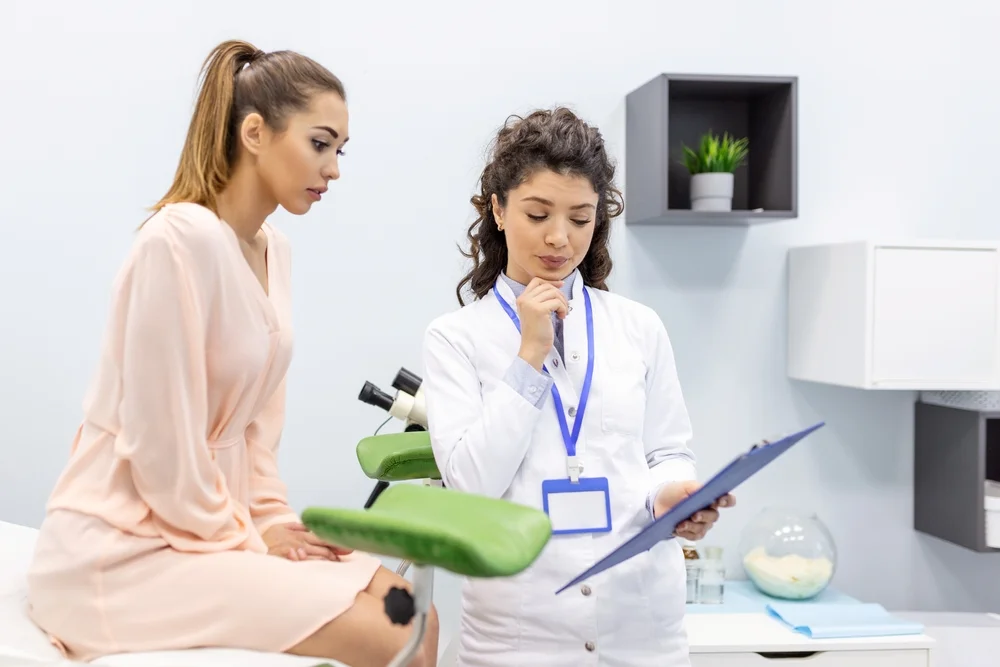Doctor discussing potential side effects and risks of VTone pelvic floor treatment with a patient during a consultation.